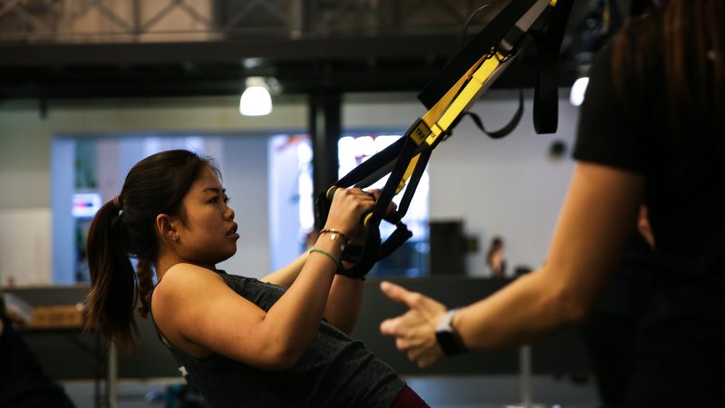 student in Heel Fit uses TRX as resistance training