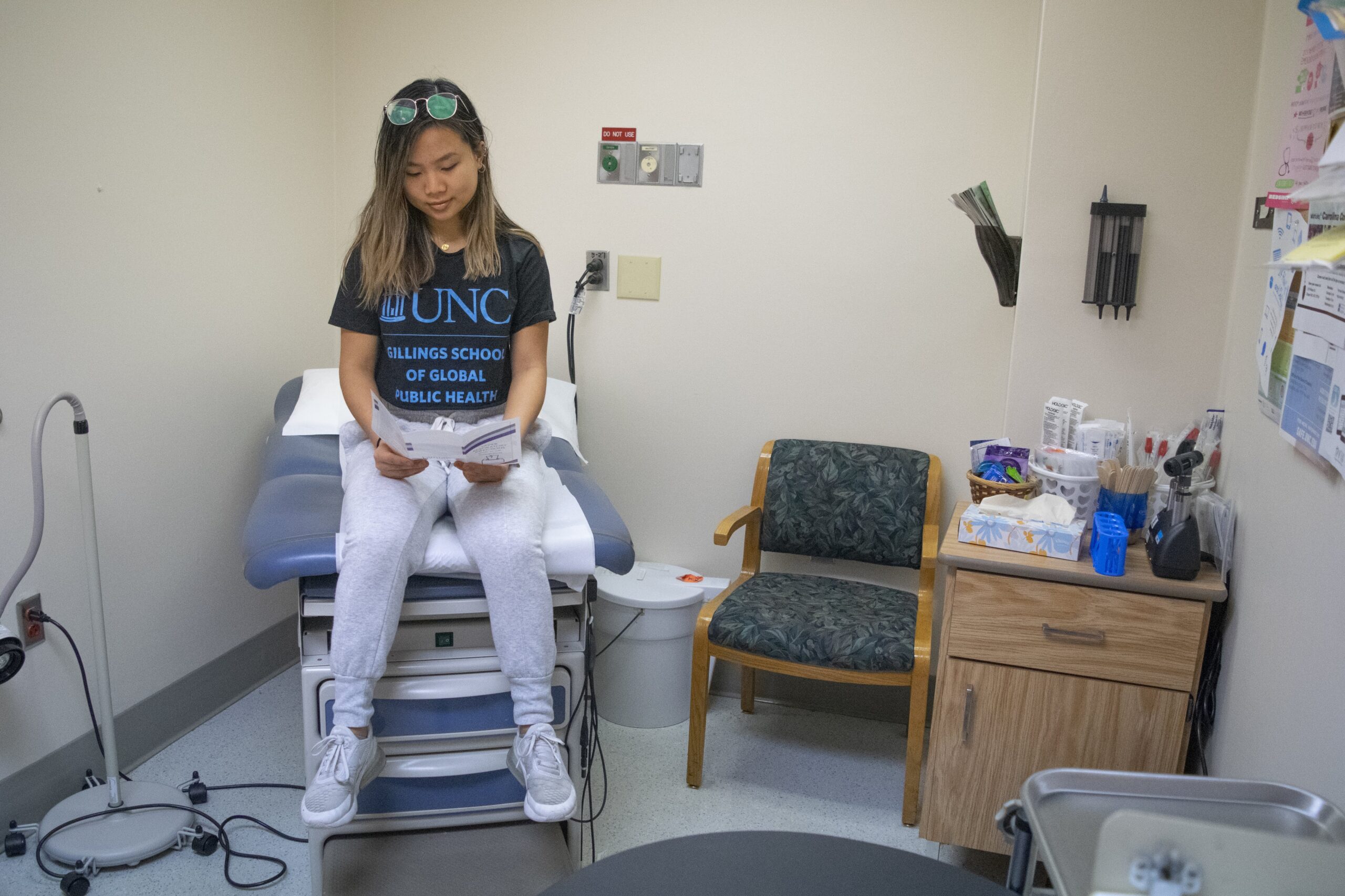 Student looks at brochure in an exam room