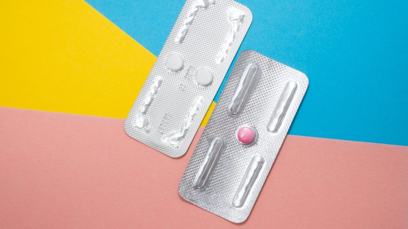 Two types of EC pills on a colorful background
