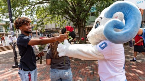 Student and RJ exchange a rose in the pit, supporting each other like we all can during finals
