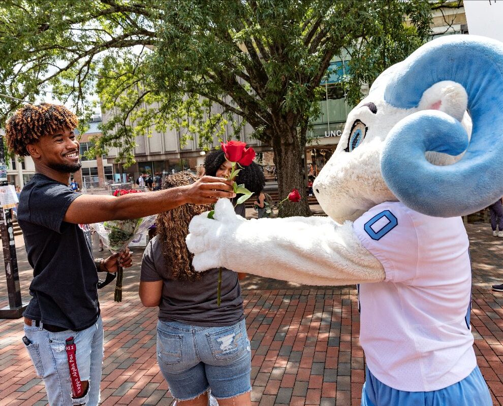 Student and RJ exchange a rose in the pit, supporting each other like we all can during finals